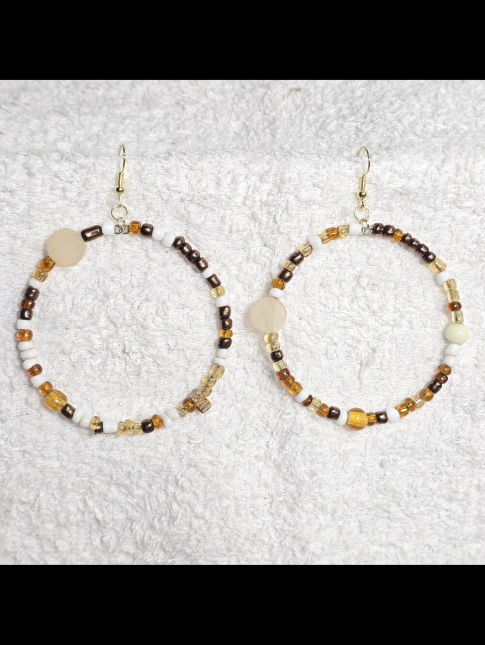 Handmade beaded hoop earrings with brown, white, and amber glass seed beads. Boh